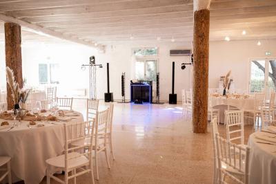 Portail en fer forgé noir et mur en pierre avec inscription ’Les Charbenes du Donelay, Domaine de réception’.