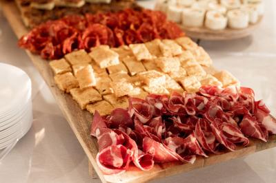 Portail en fer forgé noir et mur en pierre avec inscription ’Les Charbenes du Donelay, Domaine de réception’.