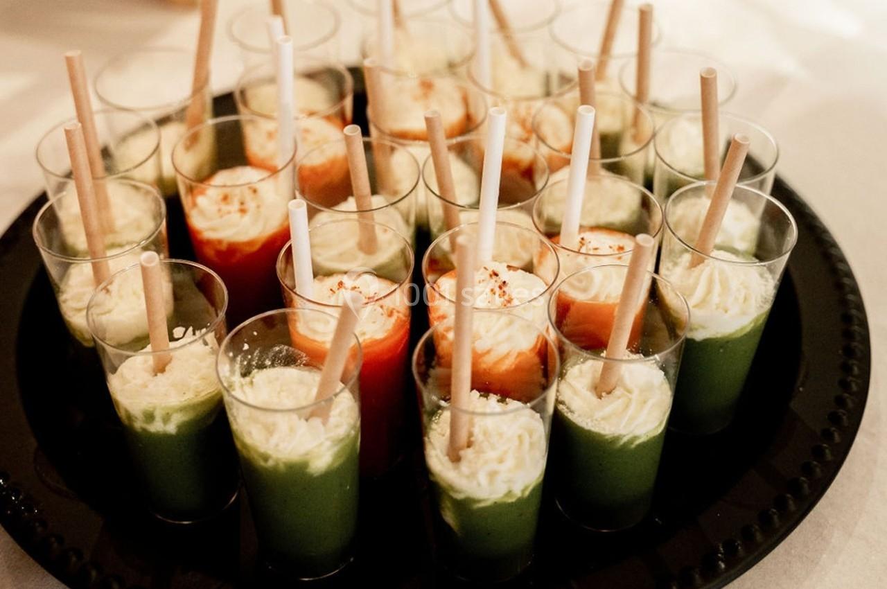 Verres de verrines colorées avec des pailles, contenant des préparations vertes, rouges et blanches, disposés sur un plateau.