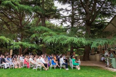 Portail en fer forgé noir et mur en pierre avec inscription ’Les Charbenes du Donelay, Domaine de réception’.