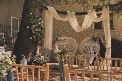 Portail en fer forgé noir et mur en pierre avec inscription ’Les Charbenes du Donelay, Domaine de réception’.