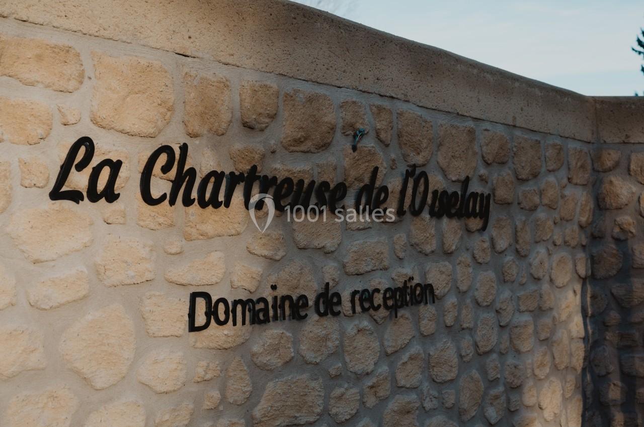 Mur en pierre avec l'inscription ’La Chartreuse de l'Oréalay, Domaine de réception’.