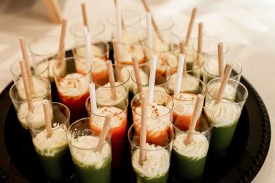 Cuillères en bois garnies de tomates, mozzarella et pesto, présentées sur un plateau pour un service individuel.