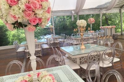 Chaises longues et tables disposées sur une pelouse, entourées de bâtiments colorés et éclairées par des guirlandes…