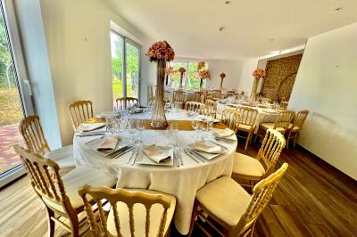 Chaises longues et tables disposées sur une pelouse, entourées de bâtiments colorés et éclairées par des guirlandes…