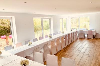 Chaises longues et tables disposées sur une pelouse, entourées de bâtiments colorés et éclairées par des guirlandes…