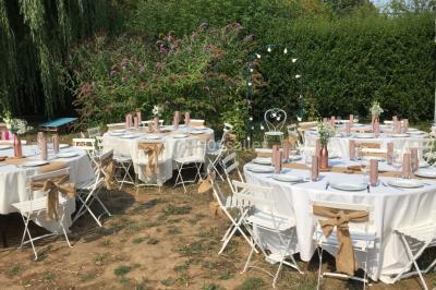 Chaises longues et tables disposées sur une pelouse, entourées de bâtiments colorés et éclairées par des guirlandes…