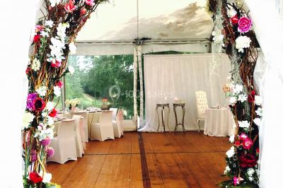 Chaises longues et tables disposées sur une pelouse, entourées de bâtiments colorés et éclairées par des guirlandes…