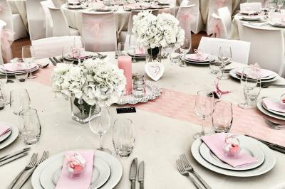 Chaises longues et tables disposées sur une pelouse, entourées de bâtiments colorés et éclairées par des guirlandes…