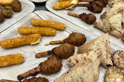 Plateau de verrines variées comprenant des préparations salées et sucrées, disposées sur une table en inox.