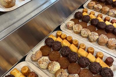 Plateau de verrines variées comprenant des préparations salées et sucrées, disposées sur une table en inox.