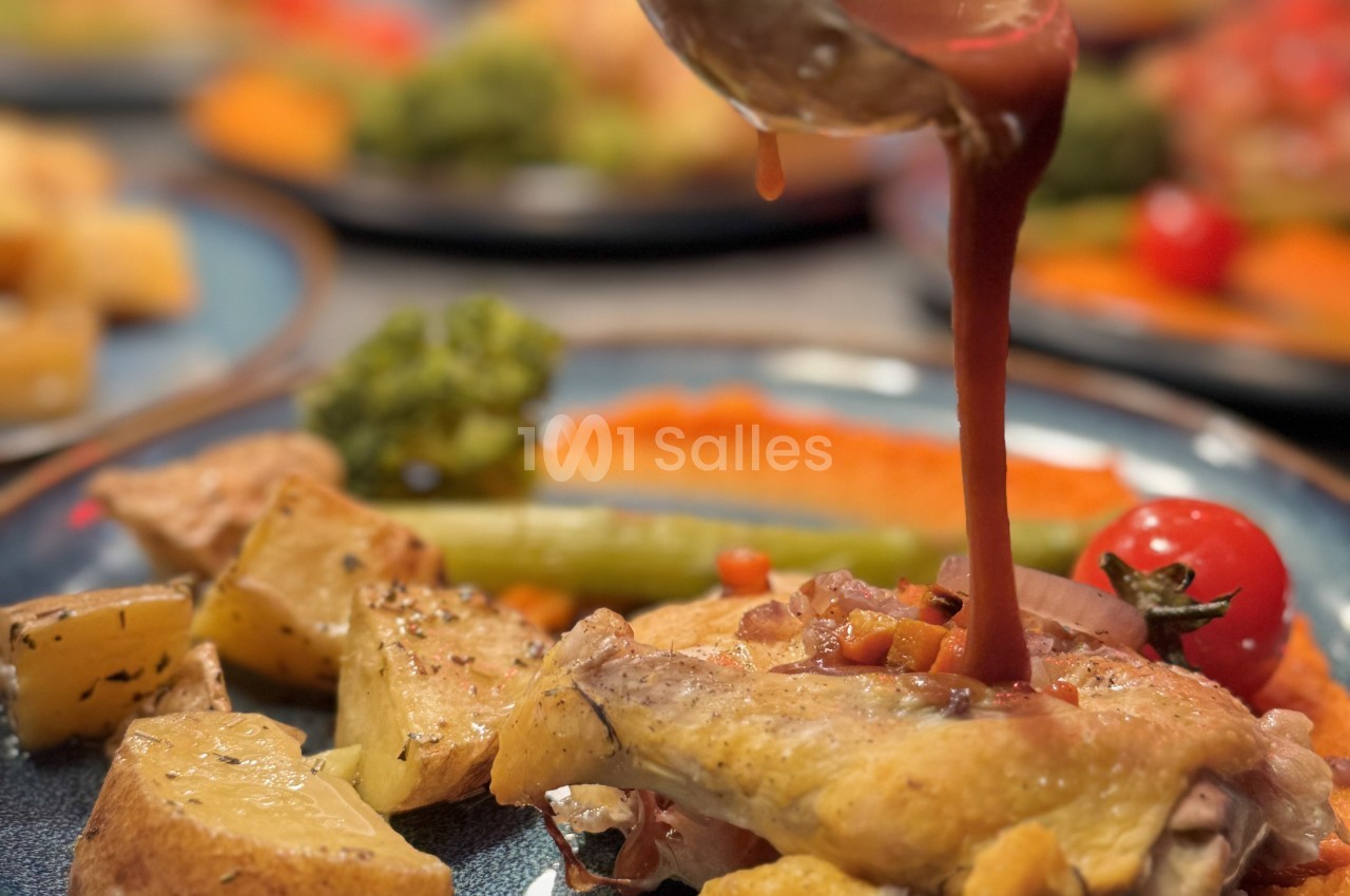 Poulet rôti servi avec des légumes, pommes de terre et sauce versée sur l'assiette.