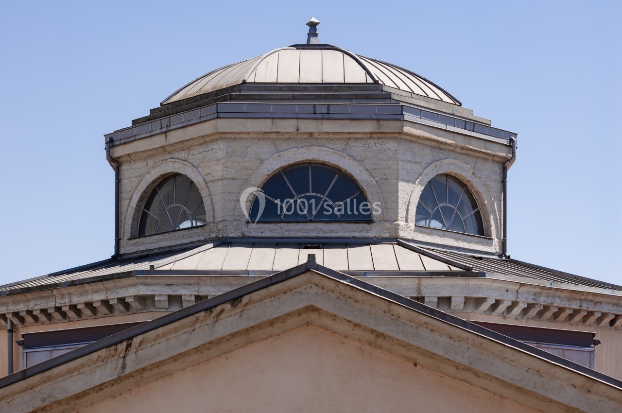 Dôme octogonal avec fenêtres cintrées et toit en métal, surmontant un bâtiment à façade triangulaire.