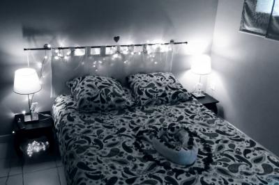 Une femme en robe de mariée est assise sur un tapis dans un jardin, tenant un bouquet de fleurs séchées.