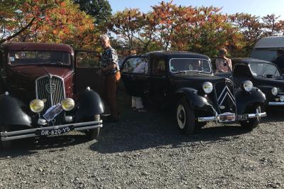 Une femme en robe de mariée est assise sur un tapis dans un jardin, tenant un bouquet de fleurs séchées.