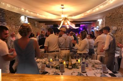 Une femme en robe de mariée est assise sur un tapis dans un jardin, tenant un bouquet de fleurs séchées.