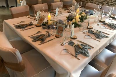 Une femme en robe de mariée est assise sur un tapis dans un jardin, tenant un bouquet de fleurs séchées.