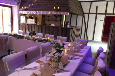 Une femme en robe de mariée est assise sur un tapis dans un jardin, tenant un bouquet de fleurs séchées.