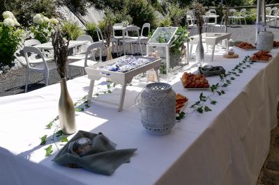 Une femme en robe de mariée est assise sur un tapis dans un jardin, tenant un bouquet de fleurs séchées.