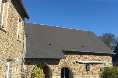 Une femme en robe de mariée est assise sur un tapis dans un jardin, tenant un bouquet de fleurs séchées.