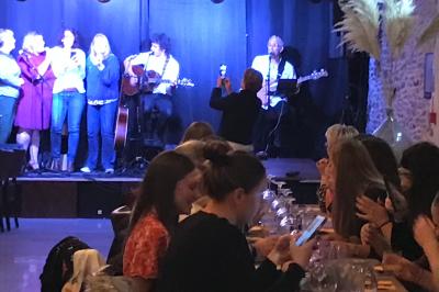 Une femme en robe de mariée est assise sur un tapis dans un jardin, tenant un bouquet de fleurs séchées.