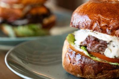 Façade d'un bâtiment avec une enseigne ’V&VICOTI’ en lettres blanches, terrasse en bois et mobilier visible en arrière-plan.