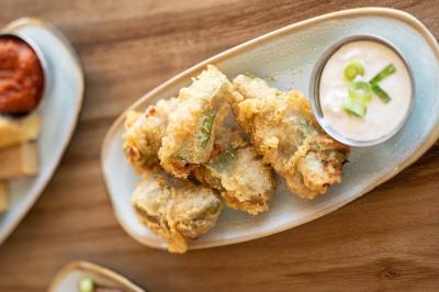 Façade d'un bâtiment avec une enseigne ’V&VICOTI’ en lettres blanches, terrasse en bois et mobilier visible en arrière-plan.