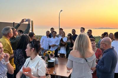 Façade d'un bâtiment avec une enseigne ’V&VICOTI’ en lettres blanches, terrasse en bois et mobilier visible en arrière-plan.