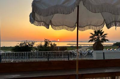 Façade d'un bâtiment avec une enseigne ’V&VICOTI’ en lettres blanches, terrasse en bois et mobilier visible en arrière-plan.