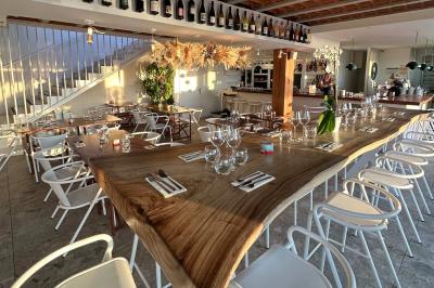 Façade d'un bâtiment avec une enseigne ’V&VICOTI’ en lettres blanches, terrasse en bois et mobilier visible en arrière-plan.