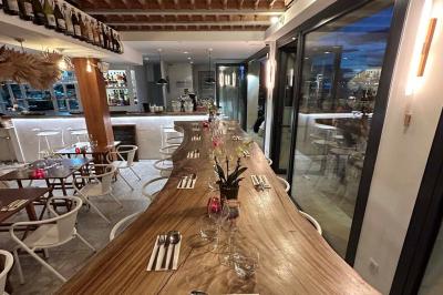 Façade d'un bâtiment avec une enseigne ’V&VICOTI’ en lettres blanches, terrasse en bois et mobilier visible en arrière-plan.