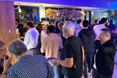 Façade d'un bâtiment avec une enseigne ’V&VICOTI’ en lettres blanches, terrasse en bois et mobilier visible en arrière-plan.