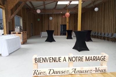 Allée bordée de végétation dense avec un château gonflable coloré visible à gauche et des bâtiments en arrière-plan.