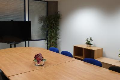 Vue aérienne d'un campus avec des bâtiments, parkings, hôtels et accès direct aux transports en commun.