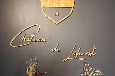 Paysage rural avec une clôture en bois, des champs verdoyants, des arbres et un bâtiment en pierre sous un ciel…