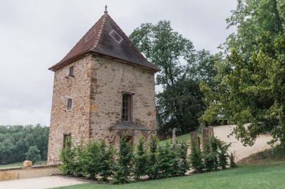 Paysage rural avec une clôture en bois, des champs verdoyants, des arbres et un bâtiment en pierre sous un ciel…