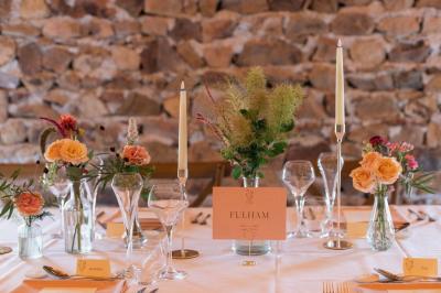 Paysage rural avec une clôture en bois, des champs verdoyants, des arbres et un bâtiment en pierre sous un ciel…
