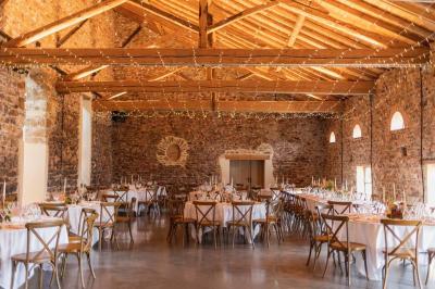 Paysage rural avec une clôture en bois, des champs verdoyants, des arbres et un bâtiment en pierre sous un ciel…
