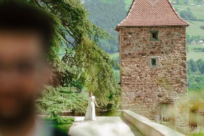 Paysage rural avec une clôture en bois, des champs verdoyants, des arbres et un bâtiment en pierre sous un ciel…