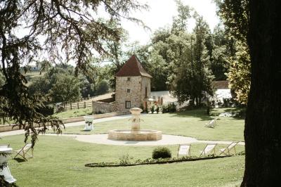 Paysage rural avec une clôture en bois, des champs verdoyants, des arbres et un bâtiment en pierre sous un ciel…