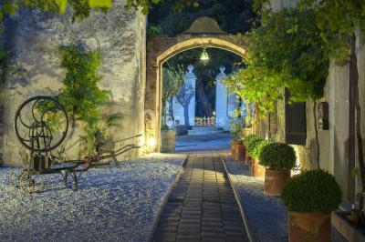 Fauteuils en rotin avec coussins blancs disposés dans un cadre naturel entouré d'arbres et de végétation.