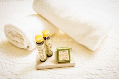 Fauteuils en rotin avec coussins blancs disposés dans un cadre naturel entouré d'arbres et de végétation.