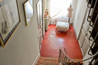 Fauteuils en rotin avec coussins blancs disposés dans un cadre naturel entouré d'arbres et de végétation.