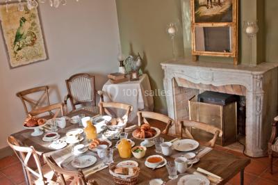 Fauteuils en rotin avec coussins blancs disposés dans un cadre naturel entouré d'arbres et de végétation.