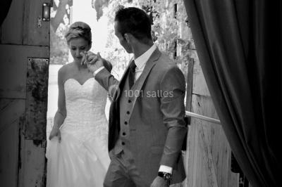 Fauteuils en rotin avec coussins blancs disposés dans un cadre naturel entouré d'arbres et de végétation.