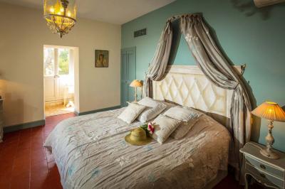 Fauteuils en rotin avec coussins blancs disposés dans un cadre naturel entouré d'arbres et de végétation.