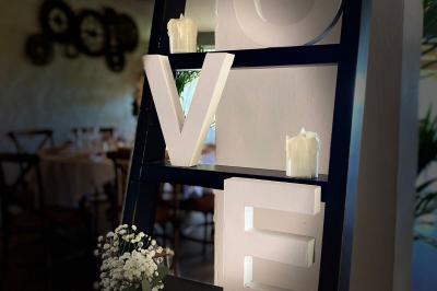 Fauteuils en rotin avec coussins blancs disposés dans un cadre naturel entouré d'arbres et de végétation.