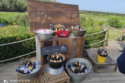 Fauteuils en rotin avec coussins blancs disposés dans un cadre naturel entouré d'arbres et de végétation.