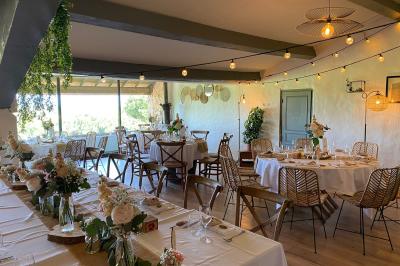 Fauteuils en rotin avec coussins blancs disposés dans un cadre naturel entouré d'arbres et de végétation.