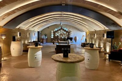 Fauteuils en rotin avec coussins blancs disposés dans un cadre naturel entouré d'arbres et de végétation.